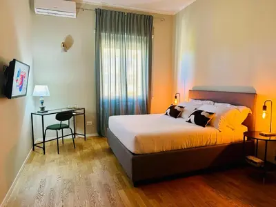 a bedroom with a bed and a table and a window at The 7th Apartment in Rome