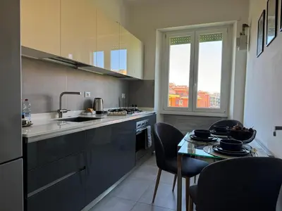a kitchen with a sink and a table with chairs at The 7th Apartment in Rome