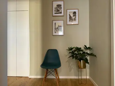a room with a green chair and a plant at The 7th Apartment in Rome