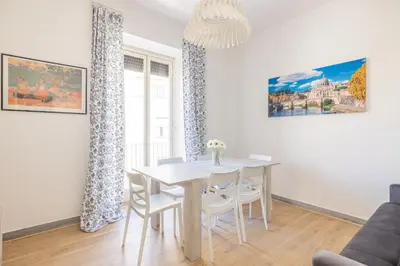 a dining room with a white table and chairs at Casa MARIA, casa vacanze Aurelio in Rome