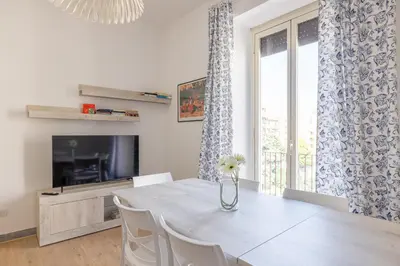 a dining room with a table with a vase of flowers at Casa MARIA, casa vacanze Aurelio in Rome
