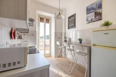 a kitchen with a counter with stools in it at Casa MARIA, casa vacanze Aurelio in Rome