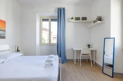 a bedroom with a bed and a desk and a window at Casa MARIA, casa vacanze Aurelio in Rome