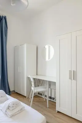 a white bedroom with a desk and a chair at Casa MARIA, casa vacanze Aurelio in Rome