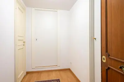 a white room with a door and a wooden floor at La CASA di EMY in Rome