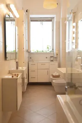 a bathroom with two sinks and a toilet and a window at Tiziano apartment-a spacious home for you in Rome in Rome