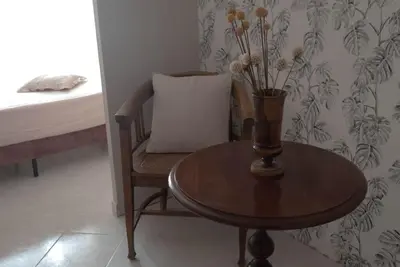 a table and a chair with a vase on it at Tiziano apartment-a spacious home for you in Rome in Rome