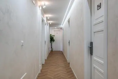 a hallway with white walls and a white door at Colonna Inn in Rome