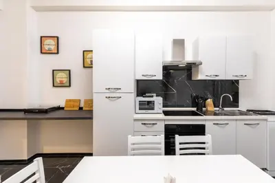 a kitchen with white cabinets and white appliances at Gregorio VII Luxury Home Apartment in Rome