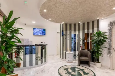 a lobby with chairs and a clock on the wall at Gregorio VII Luxury Home Apartment in Rome