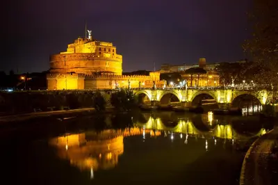 a building with a bridge over a river at night at Suite Colonna in Balestrari in Rome