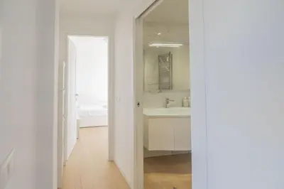 a white bathroom with a sink and a mirror at Caffarella Park Terraced 2BR Apartment in Rome