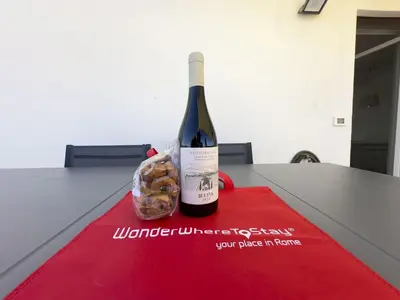 a bottle of wine and a bag of donuts on a table at Caffarella Park Terraced 2BR Apartment in Rome