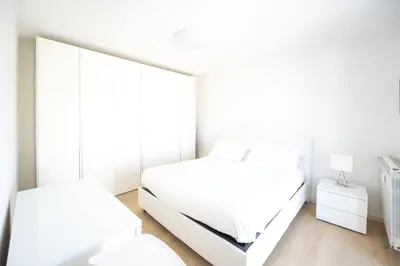 a white bedroom with a mirror and a bed at Caffarella Park Terraced 2BR Apartment in Rome
