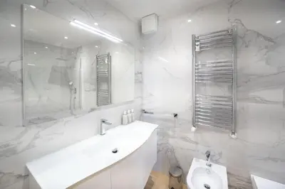 a white bathroom with a sink and a toilet at Caffarella Park Terraced 2BR Apartment in Rome