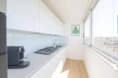 a white kitchen with a sink and a microwave at Caffarella Park Terraced 2BR Apartment in Rome