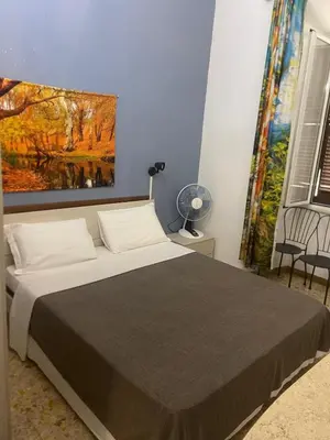 a bedroom with a bed with a painting on the wall at Parenti B&B in Rome