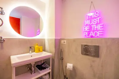 a bathroom with a sink and a sign that says this must be the place at ColoRHome in Rome