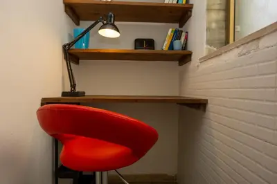 a red chair sitting under a desk with a lamp at ColoRHome in Rome
