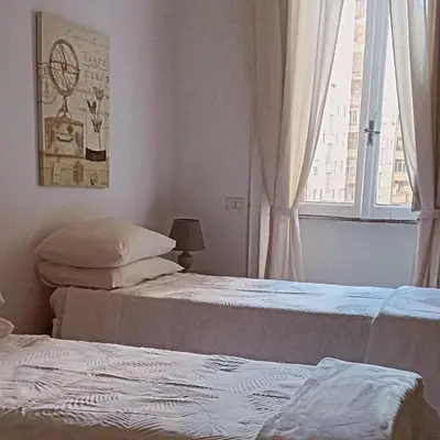 two beds in a room with a window at Rome Appartment in Rome