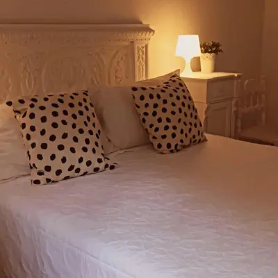 a bed with black polka dot pillows on it at Rome Appartment in Rome