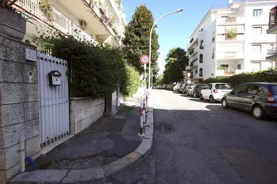 a street with cars parked on the side of the road at Ponte Milvio Lovely Garden in Rome