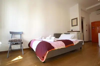 a bedroom with a bed and a chair in it at Ponte Milvio Lovely Garden in Rome