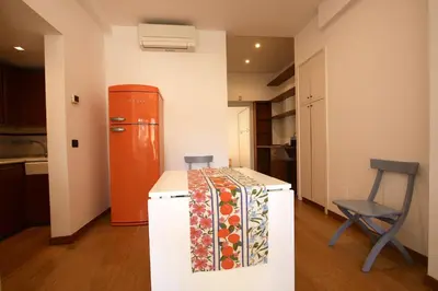 a small kitchen with a refrigerator and a chair at Ponte Milvio Lovely Garden in Rome