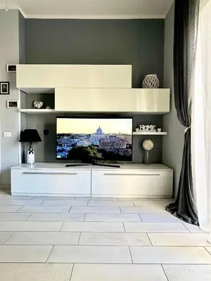 a living room with a large tv on a wall at La Casa di G Metro A tra Vaticano e Gemelli in Rome