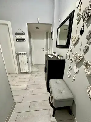 a hallway with a sink and a mirror and a stool at La Casa di G Metro A tra Vaticano e Gemelli in Rome