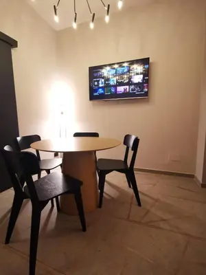 a table and chairs in a room with a tv on the wall at Auri Vatican apartment in Rome