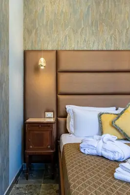 a bed with a brown headboard and a night stand at Piazza di Spagna 51 Luxury guest house in Rome