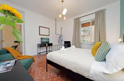 a bedroom with a bed and a couch and a window at TM Apartment in Rome