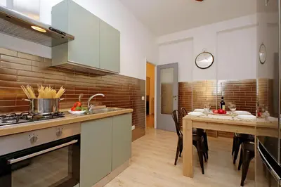 a kitchen with a table and a stove top oven at TM Apartment in Rome