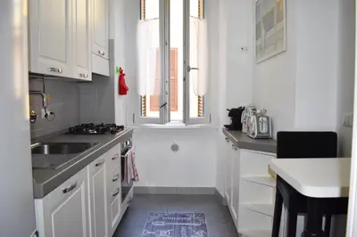 a kitchen with white cabinets and a sink and a window at Casa Ale in Rome