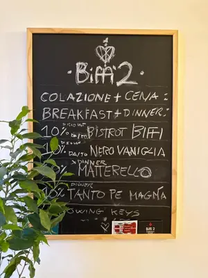 a chalkboard with a menu on a wall at Biffi 2 - Garbatella Rooms in Rome