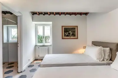 a white bedroom with a bed and a shower at Cisterna 8 in Rome