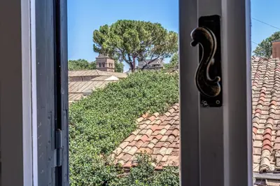 a window with a view of a roof at Cisterna 8 in Rome