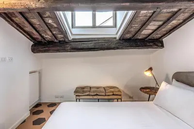 a bedroom with a bed and a skylight at Cisterna 8 in Rome
