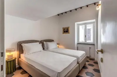 a bedroom with two beds and a window at Cisterna 9 in Rome