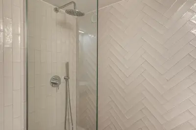 a shower with a glass door in a bathroom at Cisterna 9 in Rome