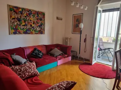 a living room with a red couch and a painting on the wall at Casa BiBi in Rome