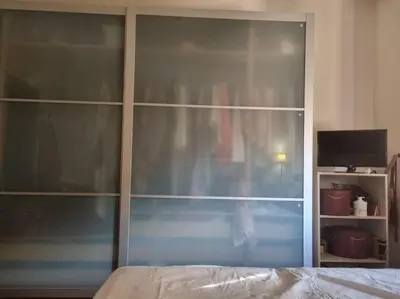 a bedroom with a large glass closet with a television at Casa BiBi in Rome
