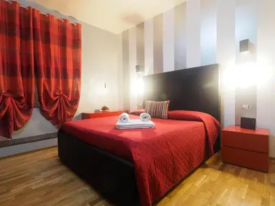 a bedroom with a bed with a red blanket at House Borgia in Rome