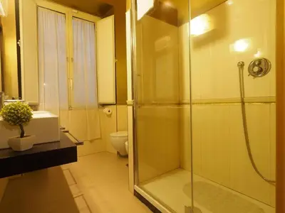 a bathroom with a glass shower and a toilet at House Borgia in Rome