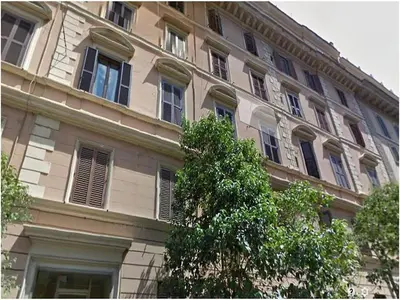 a building with windows and a tree in front of it at House Borgia in Rome