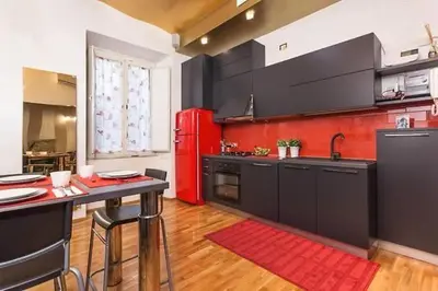 a kitchen with a red refrigerator and a table at House Borgia in Rome