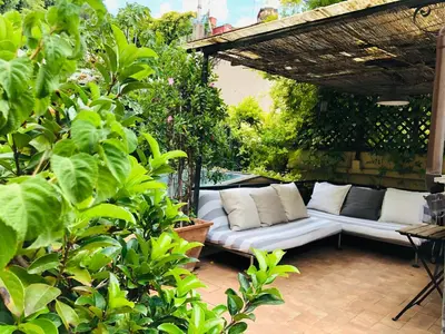 a white couch sitting under a pergola on a patio at Stylish Duplex Apartment with Private Terrace in Rome