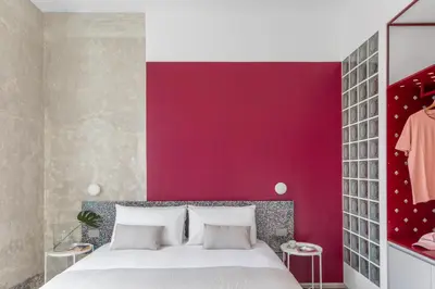 a bedroom with a bed with a red wall at Ehi Bnb in Rome