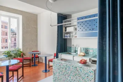 a kitchen with blue and red chairs and tables at Ehi Bnb in Rome